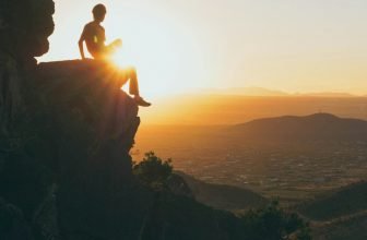 person sitting on stone during daytime